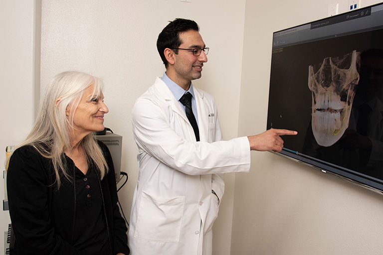 Dentist showing patient 3D x-rays
